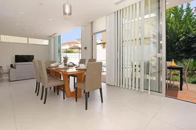 a dining room with a wooden table and chairs at Villa Sunrise Glory - 150m from Trinity Beach in Protaras