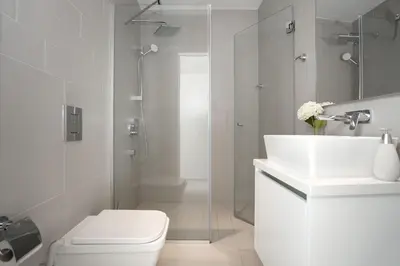 a white bathroom with a toilet and a sink at Villa Sunrise Memory - 150m from Trinity Beach in Protaras