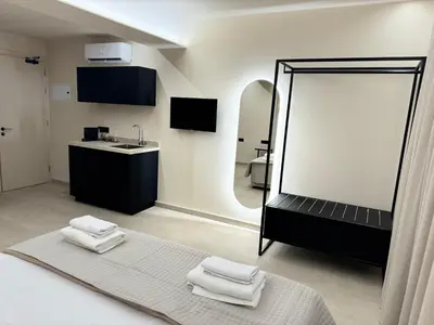 a bathroom with a mirror and a bed with towels at Home of the Muses in Ayia Napa