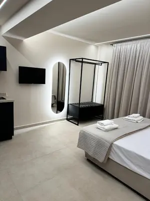 a white room with a bed and a mirror at Home of the Muses in Ayia Napa