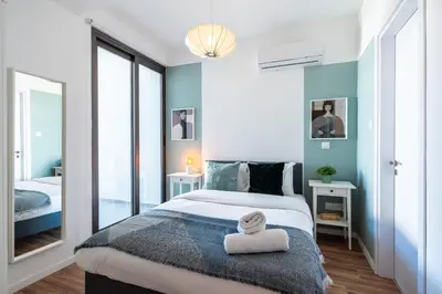 a bedroom with a large bed and a mirror at Arion 1-Bedroom Apartment in Larnaca in Larnaka