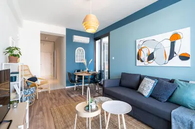 a living room with blue walls and a blue couch at Hue 1-Bedroom Apartment in Larnaca in Larnaka