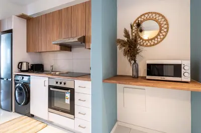 a kitchen with a washer and dryer and a microwave at Hue 1-Bedroom Apartment in Larnaca in Larnaka
