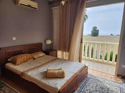 a bedroom with a large bed and a balcony at Budget Escape to the seaside in Larnaka