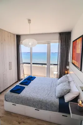a bedroom with a large bed with a view of the ocean at Finikoudes Seaview Vibe 1 Bdr Flat in Larnaka