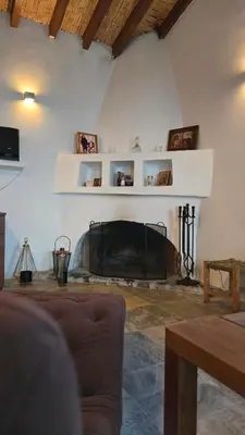 a living room with a fireplace in a house at GPPh in Pelendri