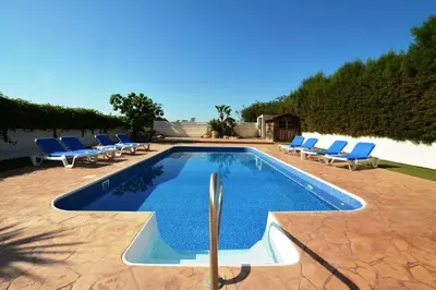 a swimming pool with blue lounge chairs and a swimming pool at Villa Chloe in Ayia Napa
