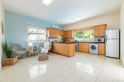 a large kitchen with wooden cabinets and a refrigerator at Pernera Blue Villa in Protaras