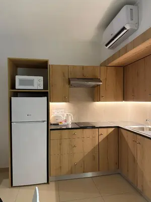 a kitchen with a white refrigerator and a microwave at Kritamo Beach Hotel Apartments in Ayia Napa