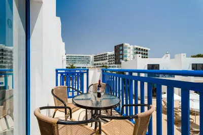 a table and chairs on a balcony with a view of the city at Kritamo Beach Hotel Apartments in Ayia Napa