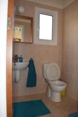 a bathroom with a toilet and a sink and a window at Villa Calm 100m from the beach in Ayia Napa