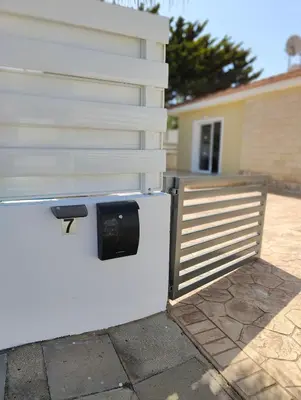 a white wall with a fence next to a house at Sunrise Experience in Ayia Napa