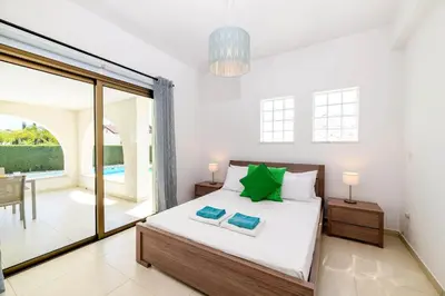 a bedroom with a bed and a sliding glass door at Kymma Bungalow #2 in Ayia Napa