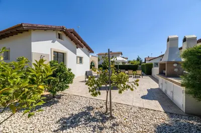 a garden with a small tree in front of a house at Kymma Bungalow #2 in Ayia Napa