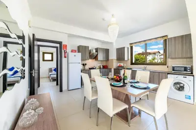 a kitchen and dining room with a table and chairs at Kymma Bungalow #2 in Ayia Napa
