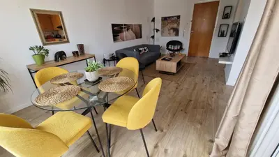 a living room with a glass table and yellow chairs at City Center Apartment 2 in Nicosia