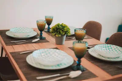a wooden table with plates and glasses on it at Mercury Apartment in Livadhia