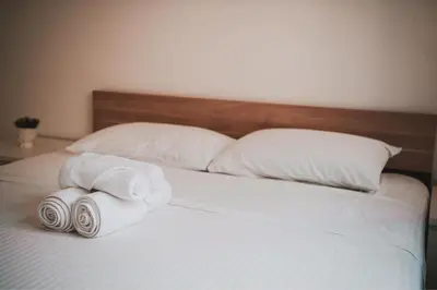 a bed with two towels and pillows on it at Mercury Apartment in Livadhia