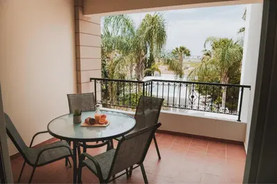 a balcony with a table and chairs and a window at Mercury Apartment in Livadhia