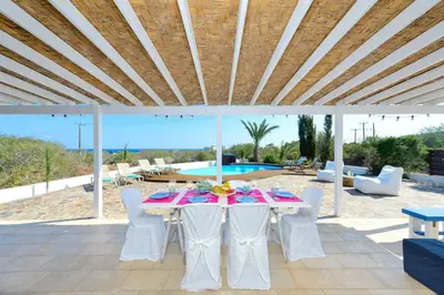 a table and chairs on a patio with a pool at Villa Marilena in Protaras