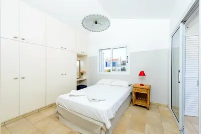 a white bedroom with a bed and a window at Villa Marilena in Protaras