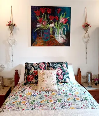 a bedroom with a bed with a painting on the wall at Traditional House in Pera in Pera