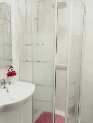 a white bathroom with a shower and a sink at Traditional House in Pera in Pera