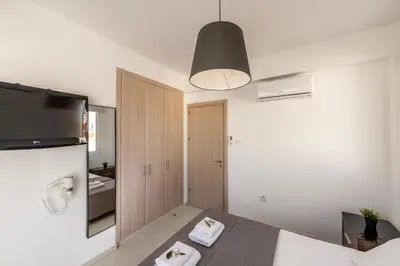 a room with a bed and a tv and a bathroom at The Second Diamond Protara - 2' Walk to Beach in Protaras
