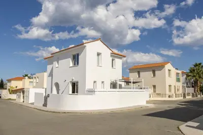 a white house on the side of a street at The Second Diamond Protara - 2' Walk to Beach in Protaras