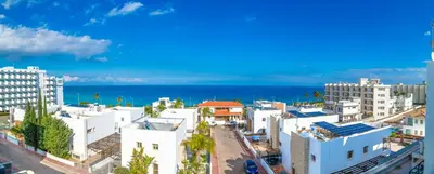 a city with white buildings and the ocean at Silver Sands Penthouse in Protaras