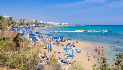 a beach with a lot of people on the sand and the water at Silver Sands Penthouse in Protaras