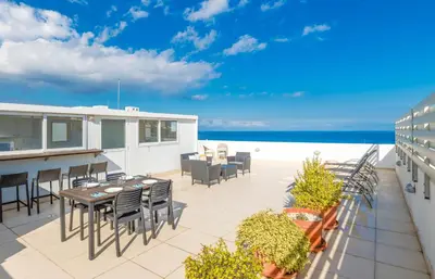 a patio with a table and chairs and the ocean at Silver Sands Penthouse in Protaras
