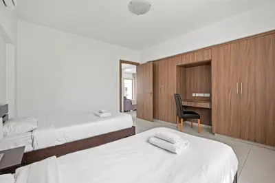 a bedroom with two beds and a desk and a chair at Downtown 2 Bedroom Apartment in Larnaka