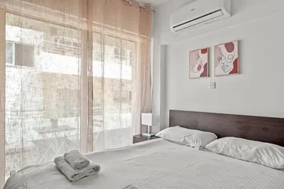 a bedroom with a bed and a large window at Downtown 2 Bedroom Apartment in Larnaka