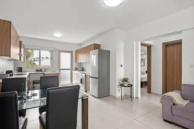 a kitchen and living room with a table and chairs at Downtown 2 Bedroom Apartment in Larnaka