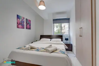 a bedroom with a bed with two towels on it at Parrots Paradise 100m from Finikoudes beachfront in Larnaka