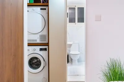 a bathroom with a washing machine and a toilet at Earth Apartment in Larnaka