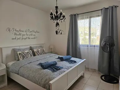a bedroom with a bed with two blue pillows on it at Mediterranean Sunrise Apartments A1 in Voroklini