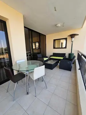 a living room with a glass table and chairs at Mediterranean Sunrise Apartments A1 in Voroklini