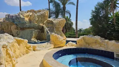 a large swimming pool in a resort with a waterfall at Mediterranean Sunrise Apartments A1 in Voroklini