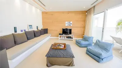 a living room with a large couch and blue chairs at Protaras Holiday Villa 100 in Protaras