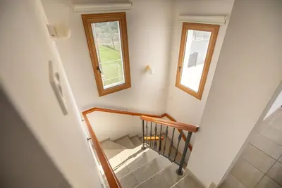 a stairway with two windows and a stair case at Konnos Villa 1 in Protaras