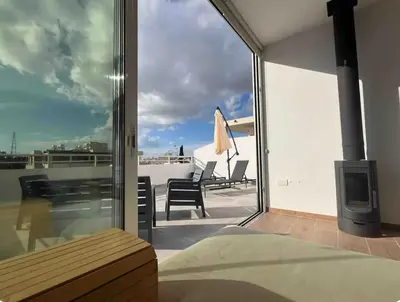 a living room with a view of a balcony at Neptune Apartment in Larnaka