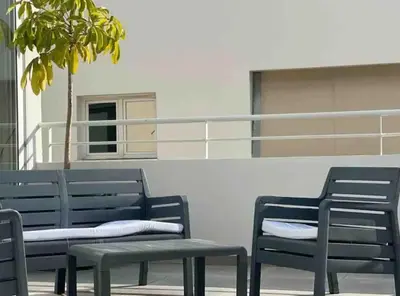 two blue benches sitting next to a building at Neptune Apartment in Larnaka