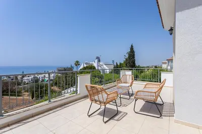 a patio with three chairs and a table on a balcony at Luxury Seaview Limassol Villa Pool Jacuzzi Sauna in Limassol