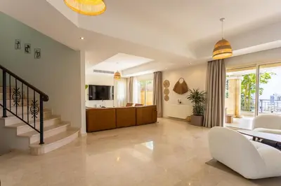 a living room with a staircase and a dining room at Luxury Seaview Limassol Villa Pool Jacuzzi Sauna in Limassol