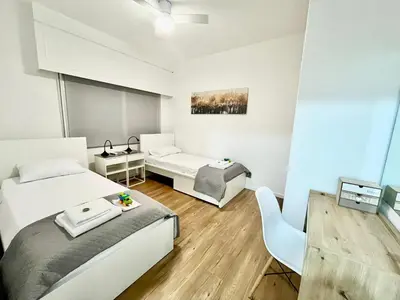 a bedroom with two beds and a desk at Modern apartment near McKenzie beach in Larnaka