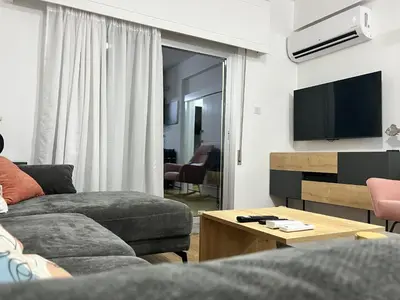 a living room with a couch and a tv at Modern apartment near McKenzie beach in Larnaka