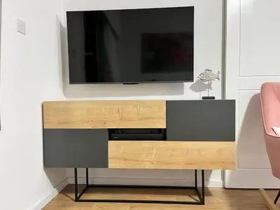 a entertainment center with a television on a wall at Modern apartment near McKenzie beach in Larnaka