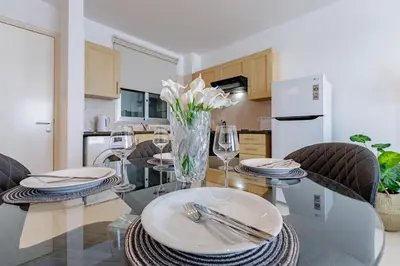 a kitchen with a table with plates and wine glasses at Stylish One-Bedroom Sea Retreat in Paralimni